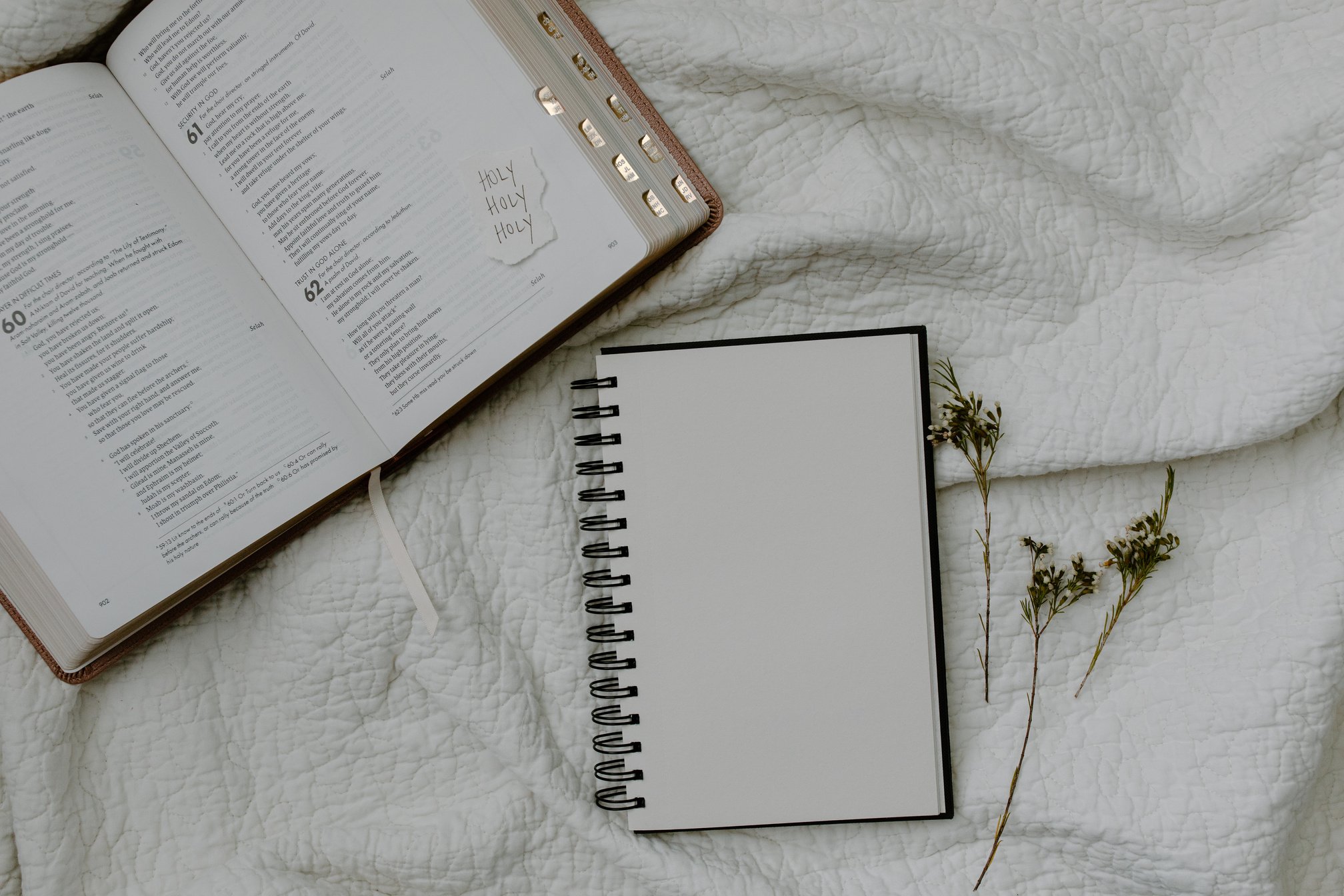 White Notebook Beside a Bible 