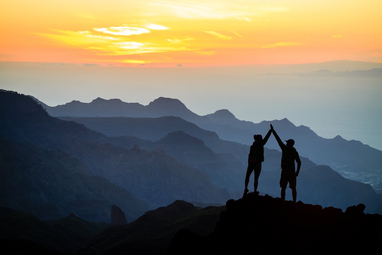 Teamwork couple climbing helping hand